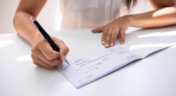 A woman filling out a check.