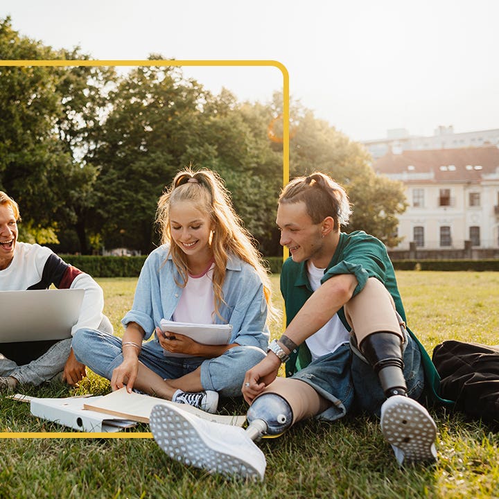 Four students sitting on the quad, studying together and enjoying each other's company